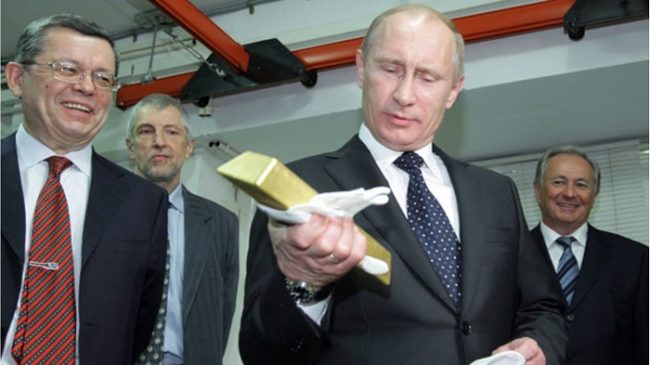 Президент России Владимир Путин держит слиток золота